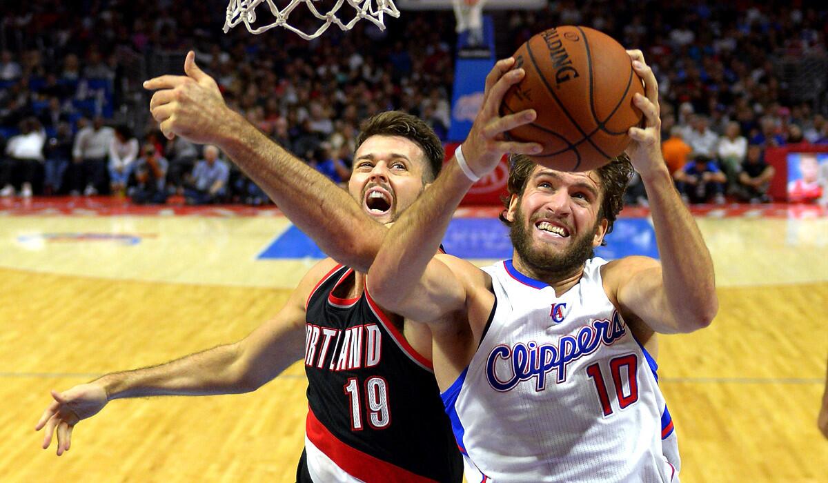 Clippers forward Spencer Hawes goes to the basket against Trail Blazers center Joel Freeland in the second half of their preseason game Friday night at Staples Center.