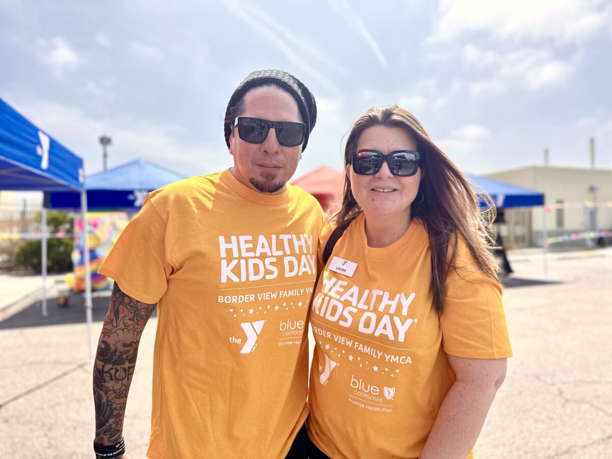P.O.D. front man Paul "Sonny" Sandoval joins in Border View YMCA event with YMCA Regional Executive Director Laura Humphreys.