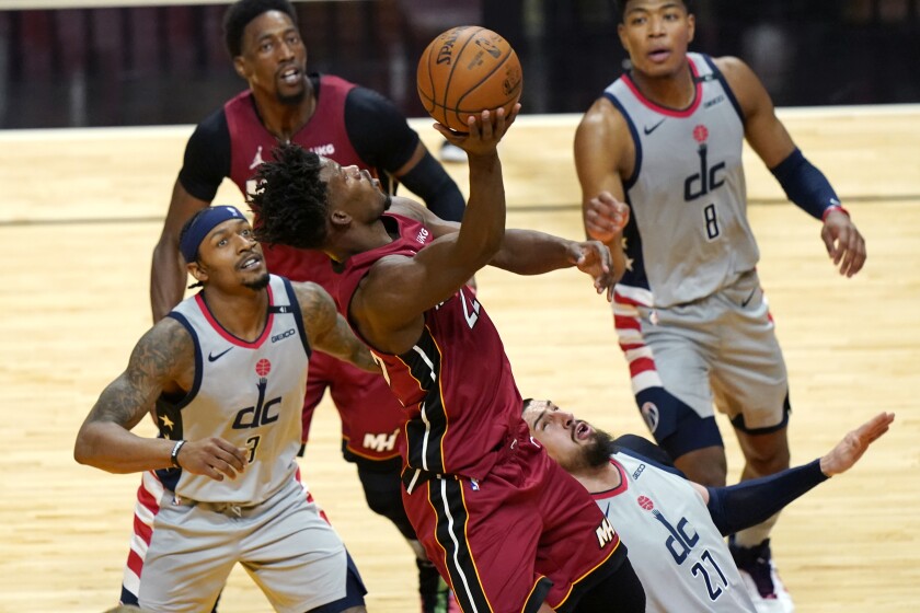 Miami Heat forward Jimmy Butler, center, goes to the basket as Washington Wizards guard Bradley Beal (3) and center Alex Len (27) defend during the second half of an NBA basketball game, Wednesday, Feb. 3, 2021, in Miami. (AP Photo/Lynne Sladky)