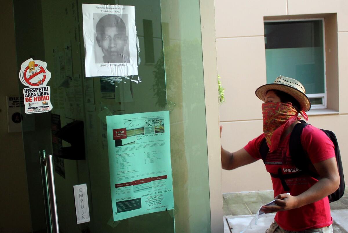 A protester in Mexico participates in an attack at the local attorney's office in Chilpancingo, Guerrero state, tied to the disappearance of 43 students nearly a year ago.