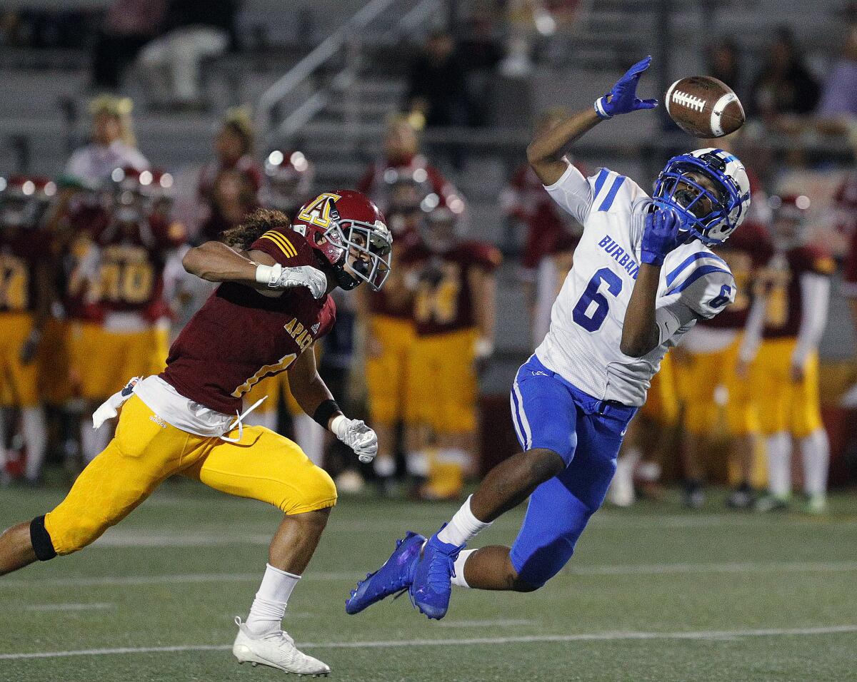 Burbank's Jarren Flowers dives ahead of Arcadia's Ty Cavallero while keeping his eye on a pass that hits his hands, and bobbles for a few yards before falling to the ground incomplete in a Pacific League football opener at Arcadia High School on Thursday, September 19, 2019.