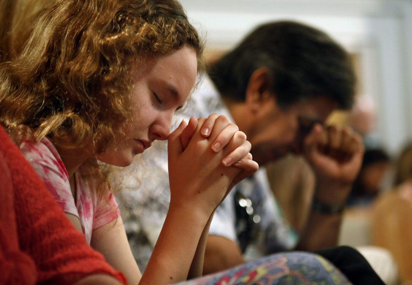 Lauren Fitzsimmons, 12, left, and Ed Staszeski pray during a service at First Church Coral Springs where prayers were said for the victims of the high school shooting.