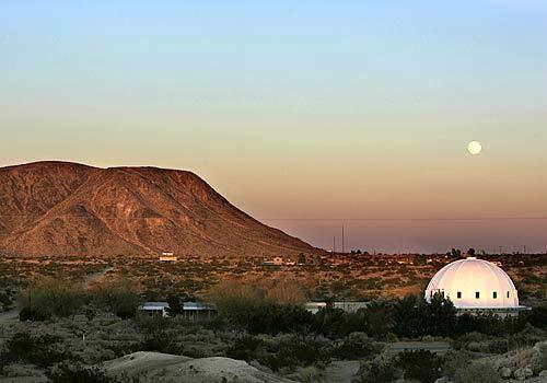 The moon rises over the white dome of the Integratron, a rejuvenation machine built by former aircraft engineer George Van Tassel in Landers, Calif. to extend people's lives, defy gravity and travel through time. Goat Mountain rises behind the round, acoustically perfect chamber, host to this year's first-ever Retro UFO convention.