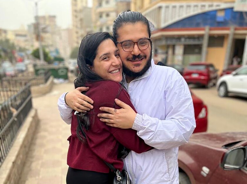 This handout image provided by Egyptian Initiative for Personal Rights (EIPR), shows rights activist who has been imprisoned for nearly two years, Patrick George Zaki hugging his sister after his release, outside the police station in Nile Delta city of Mansoura, Egypt, Wednesday, Dec. 8, 2021. A court Tuesday ordered his release pending trial. The 29-year-old rights advocate and student at the University of Bologna in Italy was charged with spreading false news about Egypt, charges that stem from a 2019 opinion piece he wrote on discrimination against Coptic Christians in Egypt. (EIPR via AP)