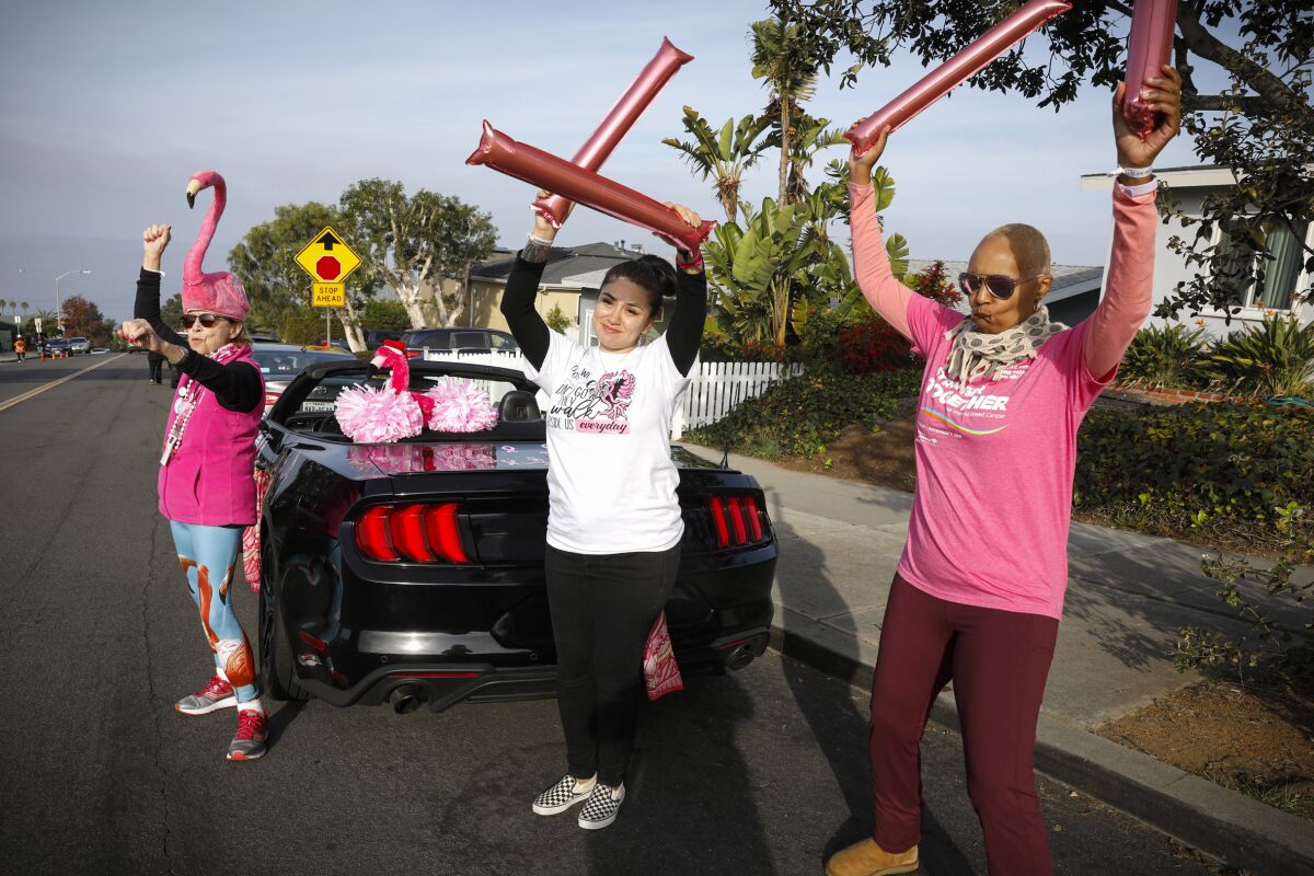 Wendy Morihiro, Sydney Encinias and Simona Santopietro (from left) cheer on walkers near Sunset View Elementary School.