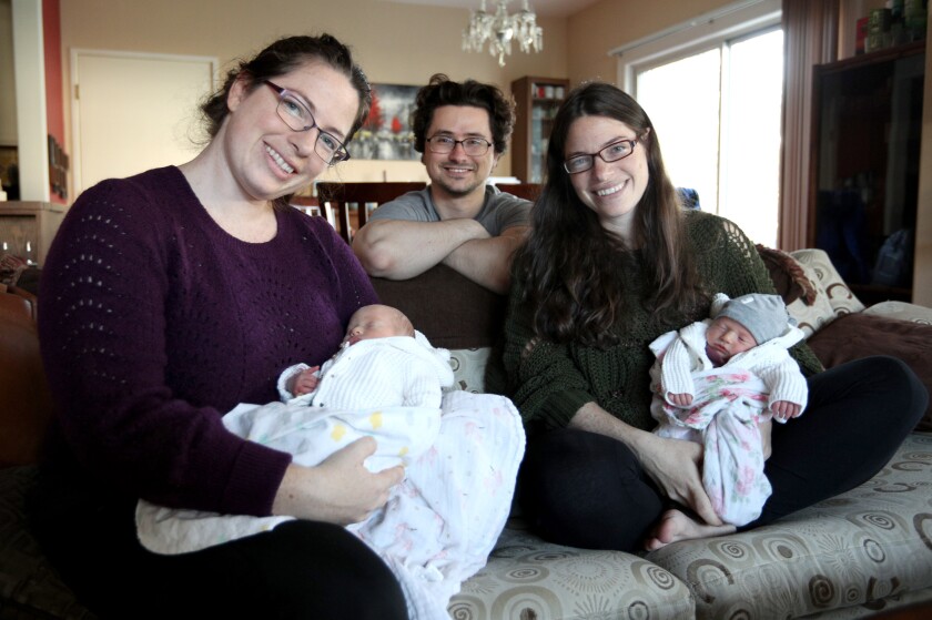 Rae Wannier, left, holds one of twin sister Jenny Tarzian's twins at the Tarzian home in Pasadena Friday with the twins' dad, Luke Tarzian. Both sets of twins were born at USC Verdugo Hills Hospital.
