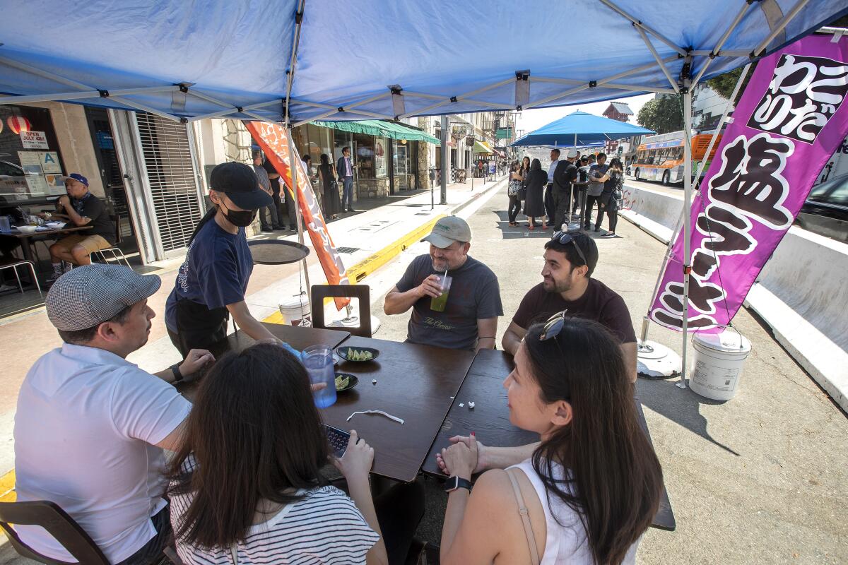 Customers sit at an outdoor table at Hachioji Craft Ramen restaurant in Little Tokyo.