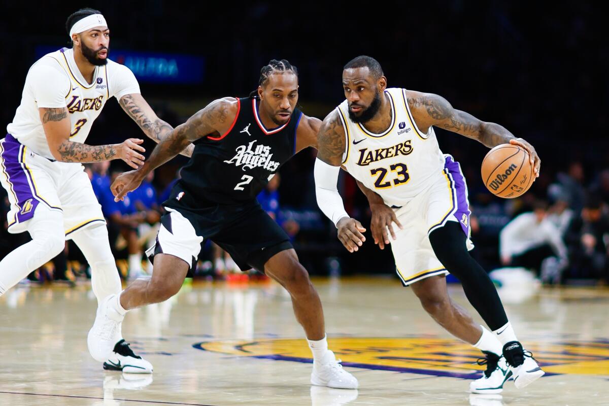Lakers star LeBron James, right, tries to drive past Clippers star Kawhi Leonard.
