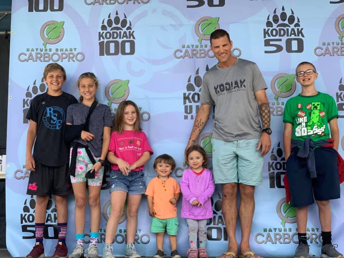 Ben Brown at the finish line of the 100-mile Kodiak Ultra with his children.