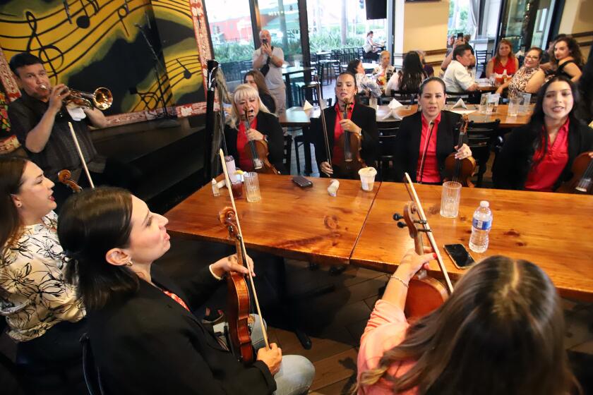 Jose Hernandez, left, plays trumpet and conducts Mariachi Reyna the first all women's mariachi group as they rehearse at Casa del Sol restaurant in Tustin on Thursday, August 29, 2024.