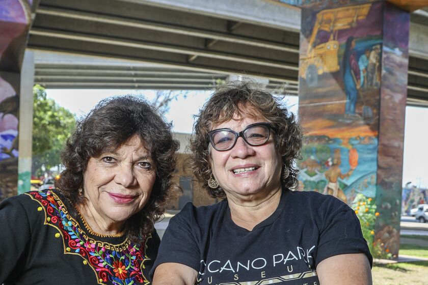 SAN DIEGO, CA - AUGUST 12: Adela C. Garcia (left) and Josie S. Talamantez pose for a photo with a Brown Beret mural in Chicano Park on Wednesday, Aug. 12, 2020 in San Diego, CA. (Eduardo Contreras / The San Diego Union-Tribune)