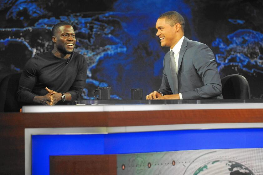 Trevor Noah, in his first night as host of Comedy Central's "The Daily Show," banters with comedian Kevin Hart.