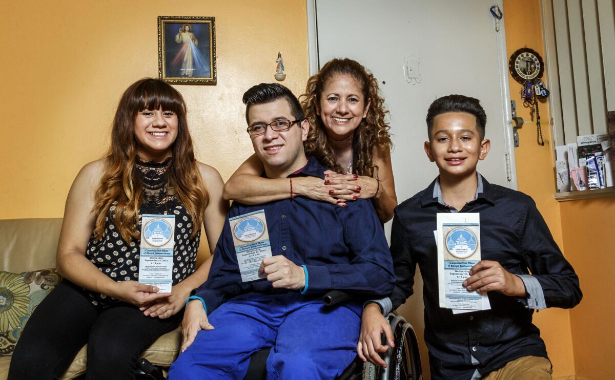 Elsa Gonzalez and her children, Dulce Maria, Lt, Christian and Edwin, photographed in their home, September 18, 2015, showing three tickets for Pope Francis' visit to Washington D.C. (Ricardo DeAratanha / Los Angeles Times)