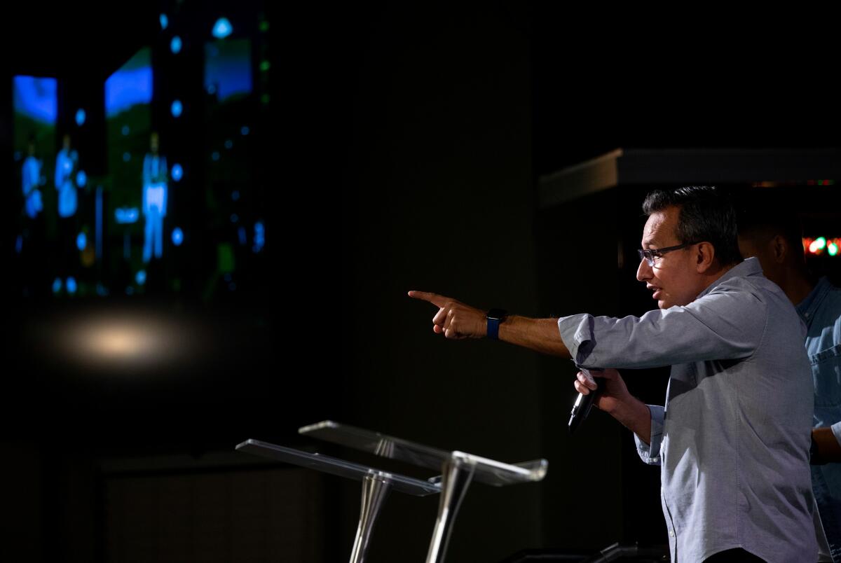 Pastor Netz Gómez points from the pulpit. 