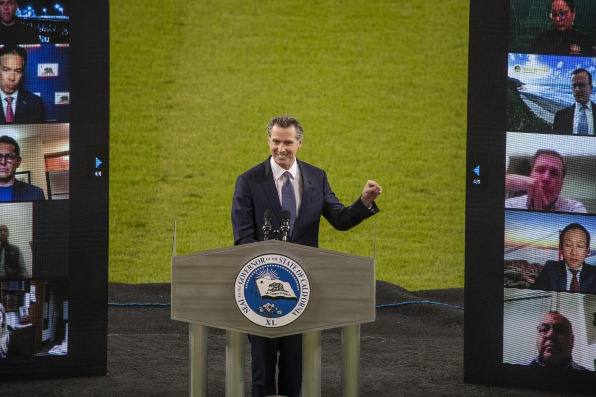  Gavin Newsom gestures from behind a lectern at Dodger Stadium