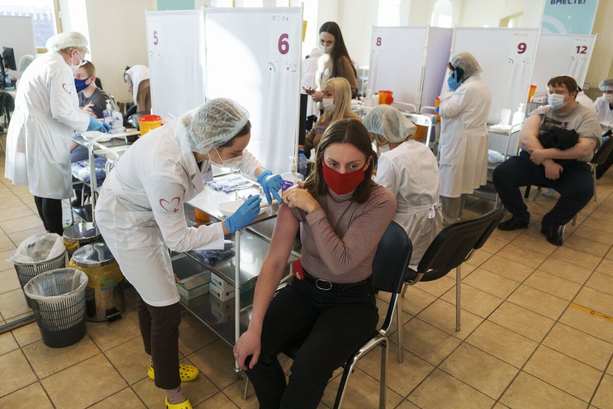 A medical worker administers a shot of Russia's Sputnik V coronavirus vaccine at a vaccination center in Moscow, Russia, Friday, Dec. 10, 2021. (AP Photo/Pavel Golovkin)