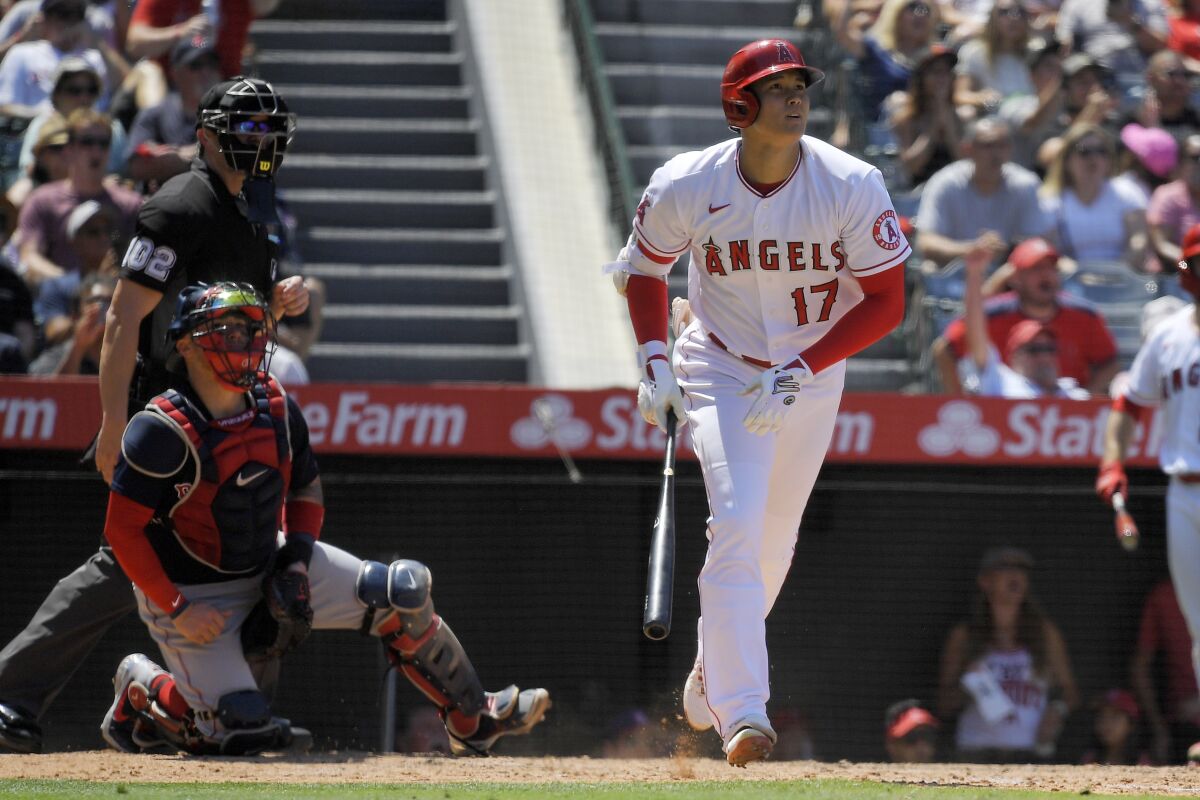 Los Angeles Angels' Shohei Ohtani, right, heads to first after hitting a solo home run as Boston Red Sox catcher Christian Vazquez, center, and home plate umpire Adam Beck watch during the fifth inning of a baseball game Wednesday, July 7, 2021, in Anaheim, Calif. (AP Photo/Mark J. Terrill)