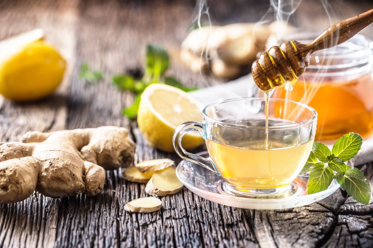 Ginger tea with honey, lemon and mint leaves.
