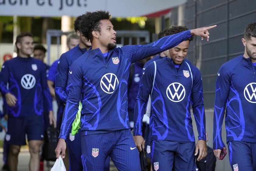 Weston McKennie, left, shows the way to Christian Pulisic, right, as they arrive during a training session.