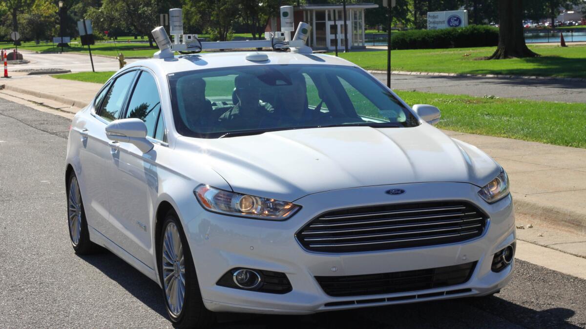 An experimental Ford Fusion autonomous car, lidar sensors on the roof, drives itself in Dearborn, Mich. on Sept. 12