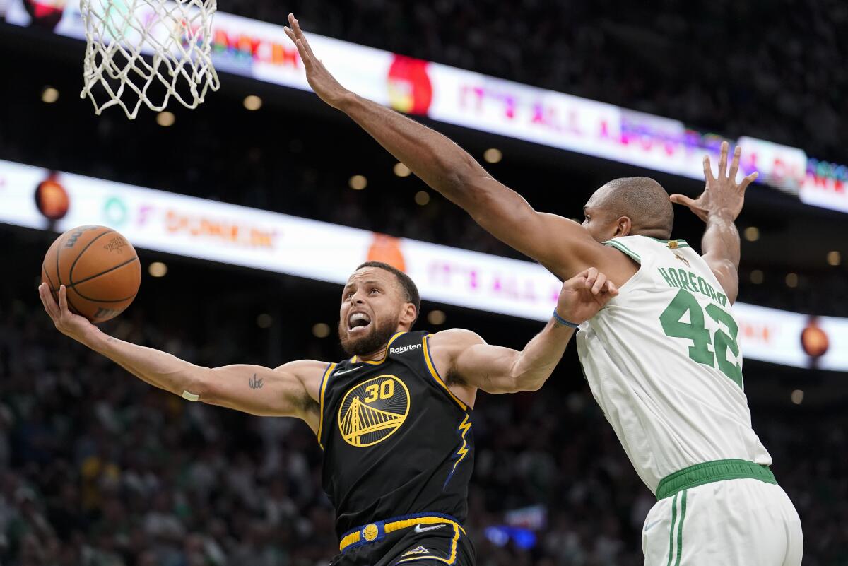 Warriors guard Stephen Curry goes up for a shot against Celtics center Al Horford during the fourth quarter June 10, 2022.