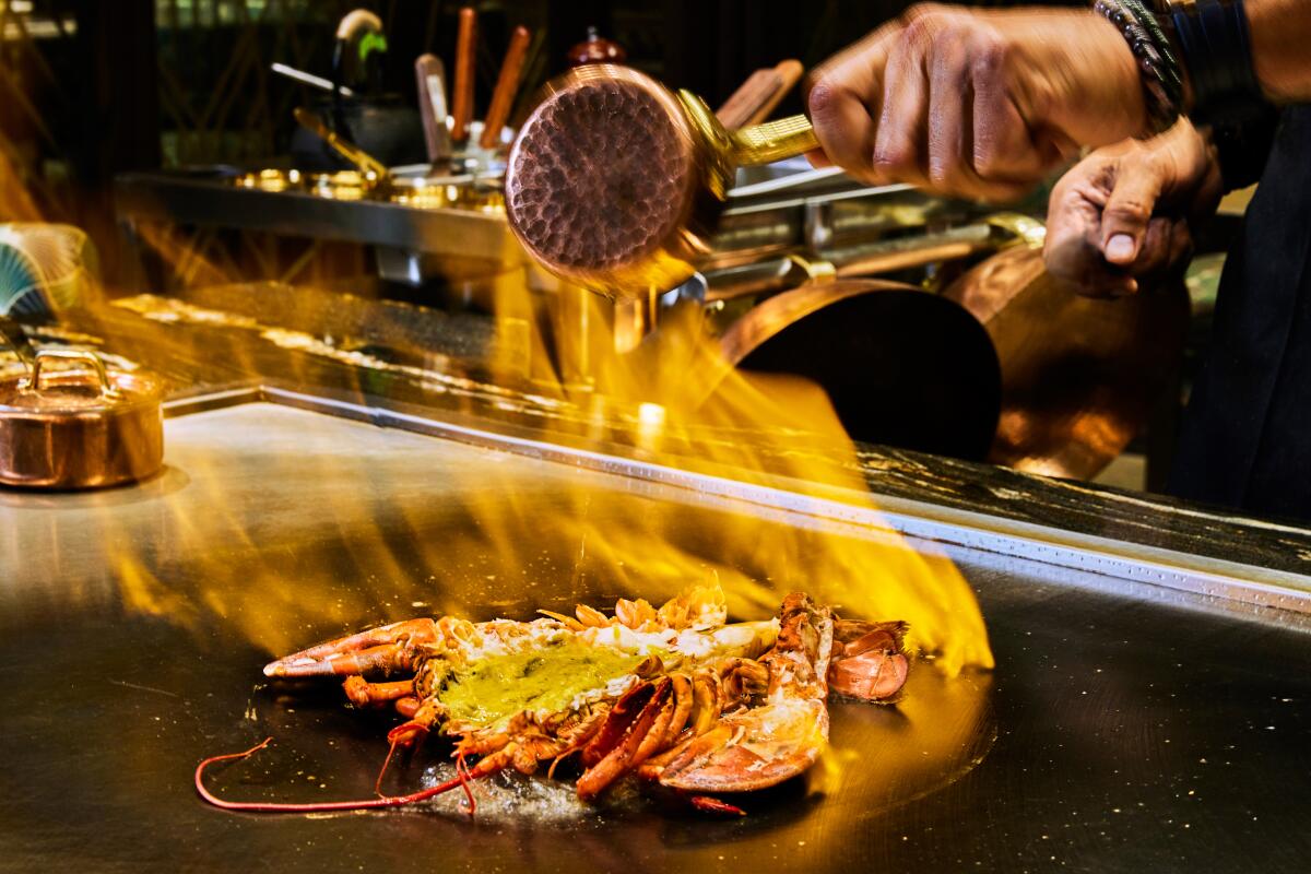 A whole, splayed lobster ablaze on the teppanyaki grill at Level 8's Maison Kasai