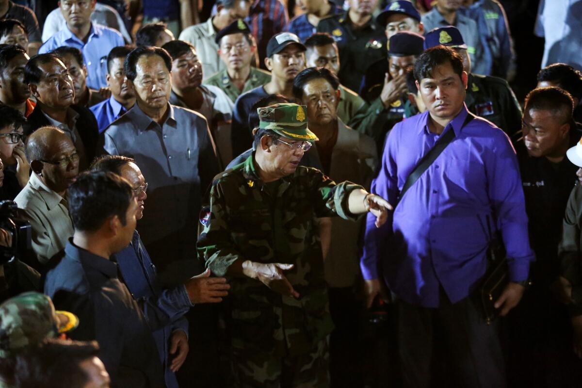 Cambodia's Prime Minister Hun Sen (C in uniform) visits the site of an under-construction building two days after it collapsed in Sihanoukville early on June 24, 2019. - Victims of a Cambodia building collapse were buried alive as they slept, a survivor said on June 23, as the death toll at the Chinese-owned site rose to 18 and hopes faded for finding more survivors.
