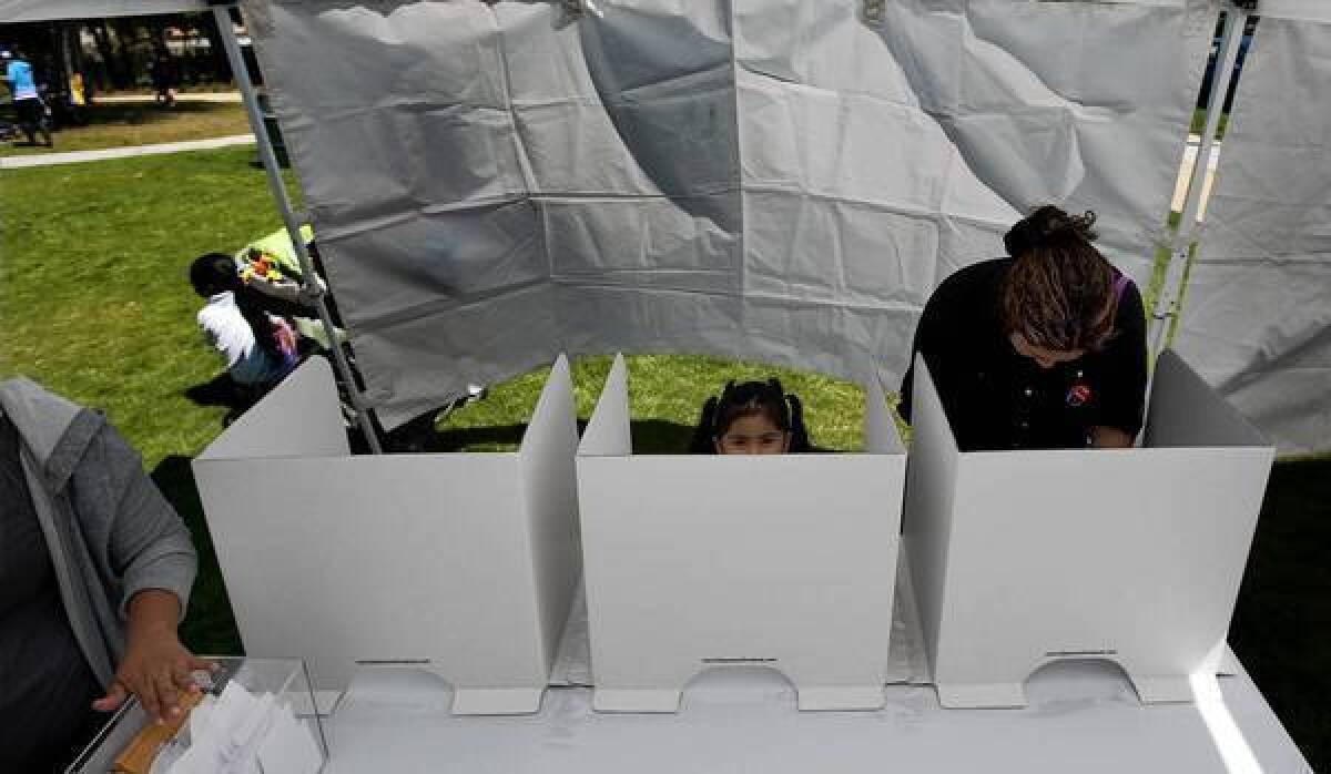 Edith Medrano, with 3-year-old daughter Graidy, casts a ballot to determine the future of 24th Street Elementary School in Jefferson Park. The balloting was the result of a parent-trigger petition.