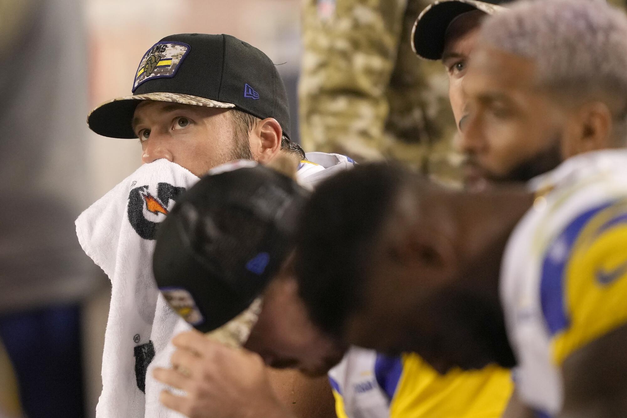 Rams quarterback Matthew Stafford sits on the bench with his teammates.