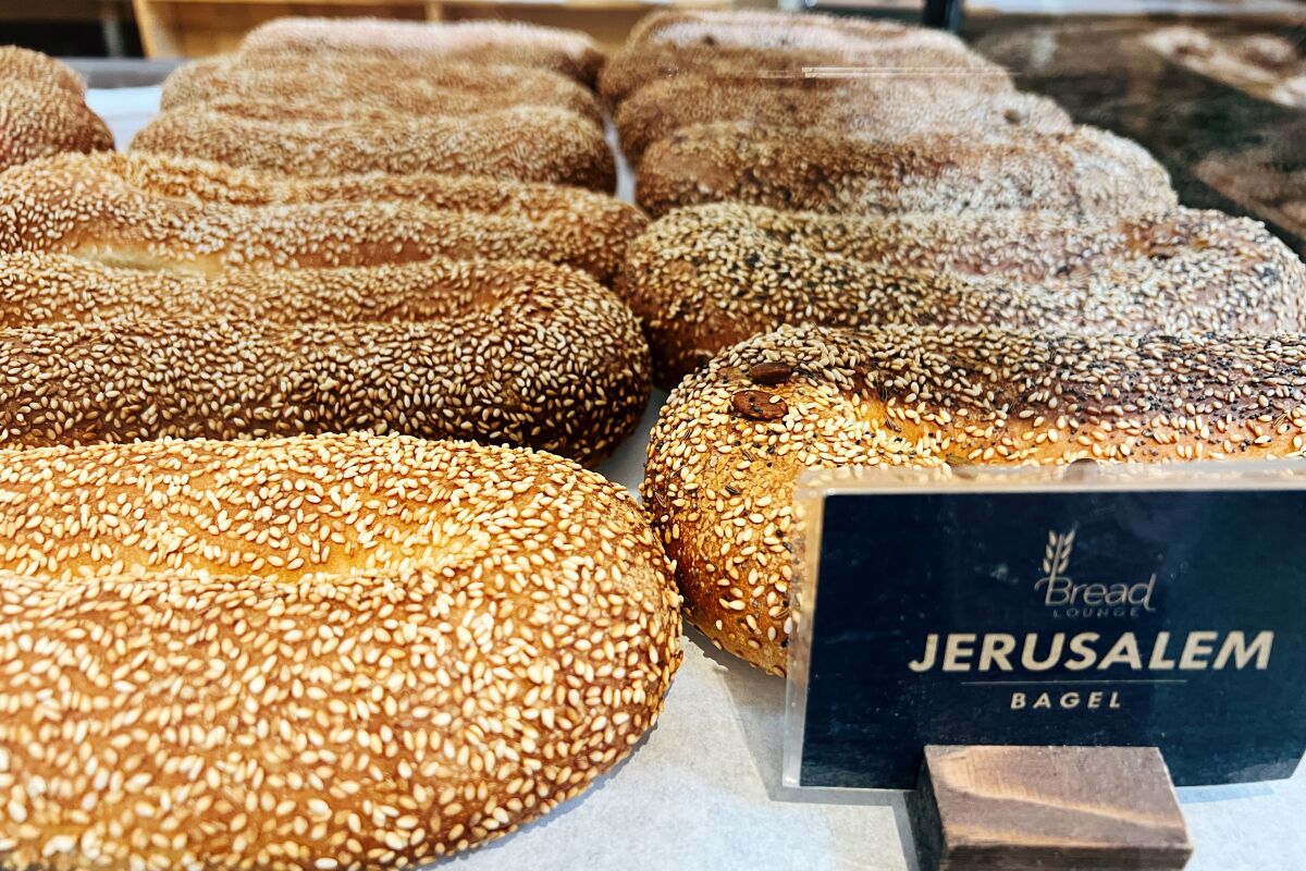 Jerusalem bagels lined up in a bakery case.