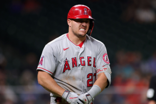 HOUSTON, TEXAS - APRIL 22: Mike Trout #27 of the Los Angeles Angels grimaces in pain after being hit by a pitch.