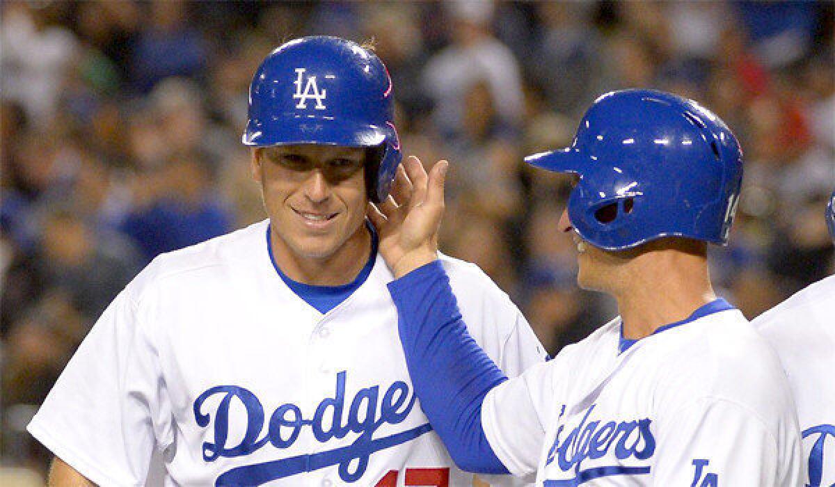 A.J. Ellis, left, is congratulated by teammate Mark Ellis after hitting a grand slam during the Dodgers' 9-8 victory over the Angels in the second game of the Freeway Series on Friday.