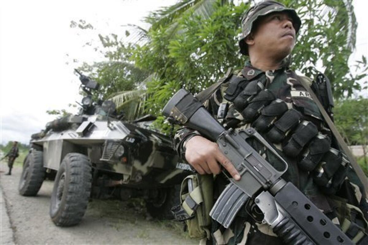 An army trooper stays alert at a military checkpoint in Ampatuan, Maguindanao province, southern Philippines on Wednesday Nov. 25, 2009. Philippine authorities, under intense public pressure to make arrests in the country's worst election massacre, said Wednesday they are investigating a member of a powerful clan allied with the government along with four police commanders.(AP Photo/Aaron Favila)