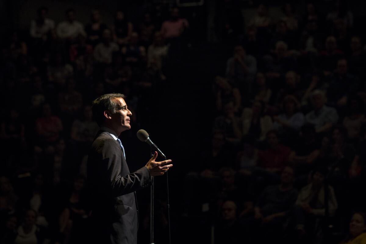 Mayor Eric Garcetti spotlighted in profile at a microphone 