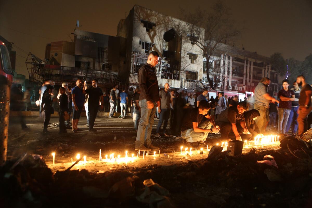 Residentes encienden velas en el lugar donde se registró un brutal ataque con auto bomba en Karada, un concurrido distrito comercial de la capital iraquí, Bagdad, donde las víctimas realizaban compras para el feriado Eid al-Fitr, el 3 de julio de 2016. (AP Foto/Hadi Mizban)