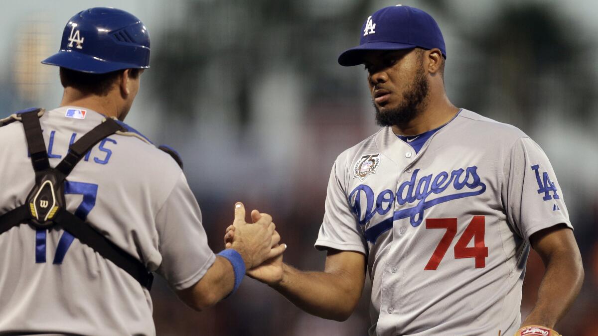 Dodgers catcher A.J. Ellis, left, and closer Kenley Jansen celebrate the team's 4-3 win over the San Francisco Giants on Sunday.