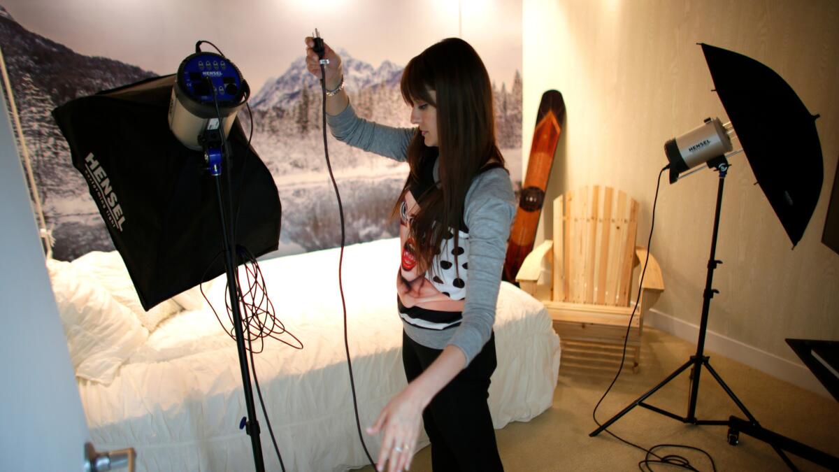 Photographer Anna Krivenkoff sets up lights for a photo shoot at Studio 20.