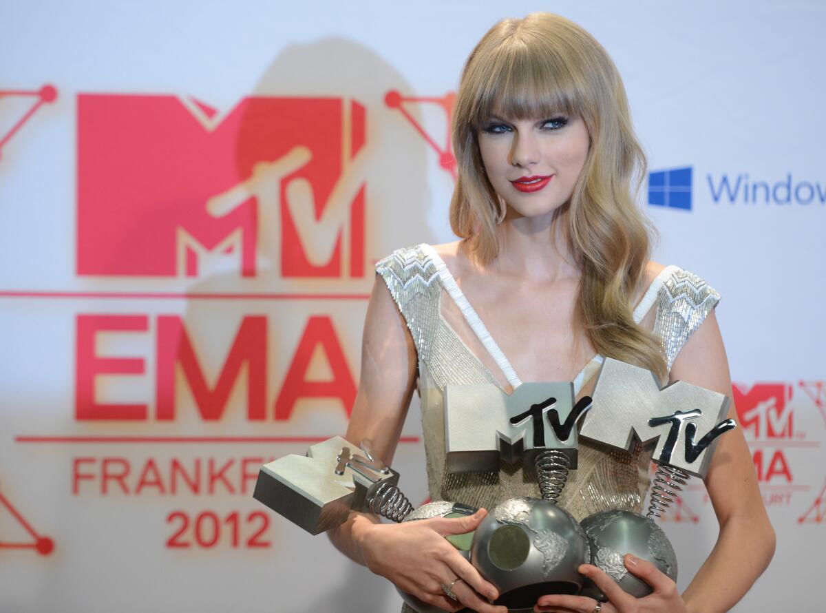 Taylor Swift, who won three European MTV Awards over the weekend, remains at No. 1 in the U.S. for a third week with her album "Red."