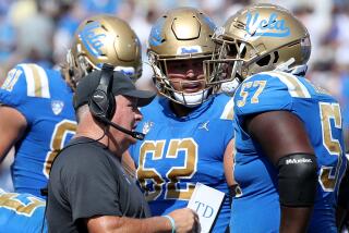 UCLA coach Chip Kelly talks with his players on the sideline during a 2022 game 