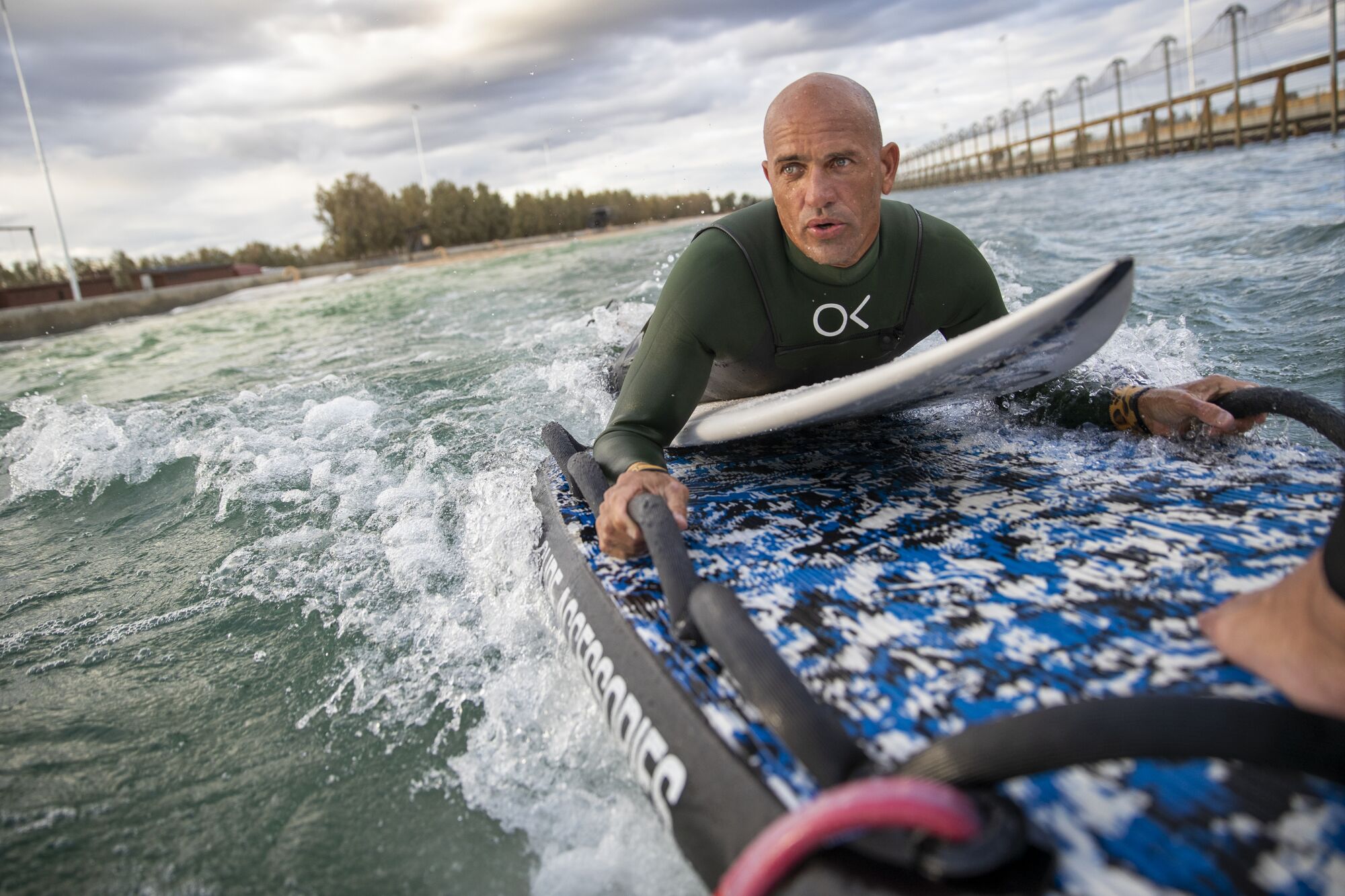 Kelly Slater is taken out to his surfing position on the back of a wave runner during production on “The Ultimate Surfer."