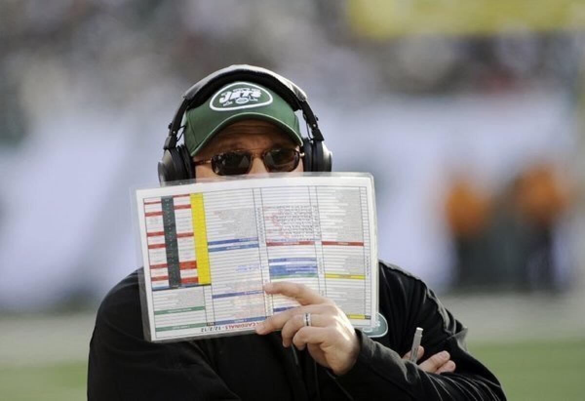 Tony Sparano holds a play list during the first half of a game against the Arizona Cardinals.