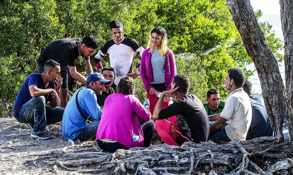 Un grupo de migrantes cubanos se reúne cerca de un camino en la isla Duck Key 