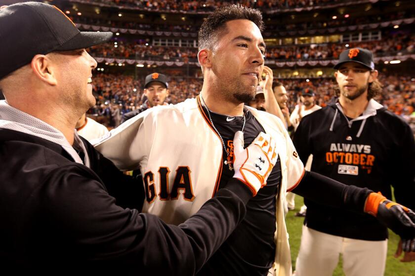 Giants left fielder Travis Ishikawa is helped to his feet by pitcher Tim Hudson after a wild celebration following his game-winning home run against the Cardinals in Game 5 of the NLCS on Thursday night in San Francisco.