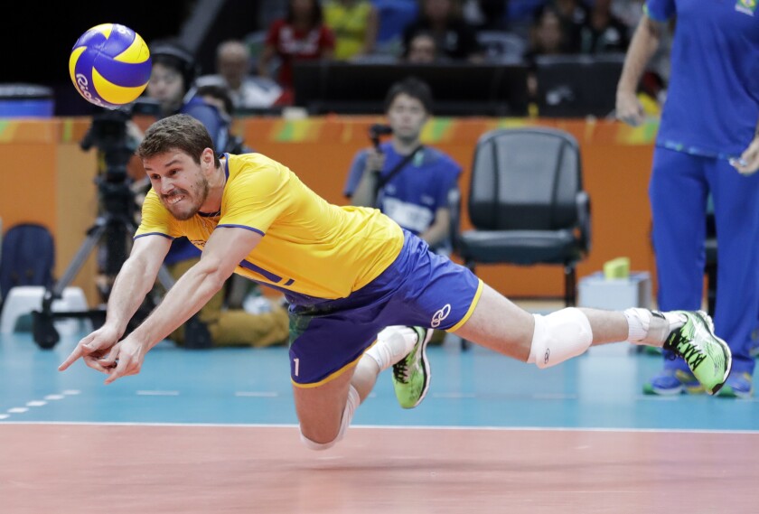 FILE - In this Aug. 9, 2016, file photo, Brazil's Bruno Rezende dives for the ball during a men's preliminary volleyball match against Canada at the Summer Olympics in Rio de Janeiro. Both defending champions in volleyball are in good position to contend for a repeat with Rezende back for a fourth Olympics for the Brazilian men after winning silver in 2008 and ‘12 and gold at home in Rio five years ago. (AP Photo/Jeff Roberson, File)