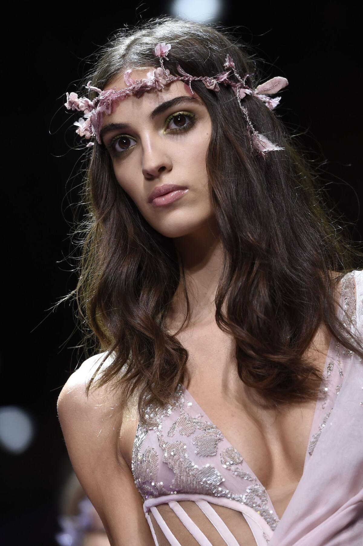 A model wears a floral headband during Versace fashion show.