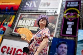 FILE - A tour guide fans herself while working in Times Square as temperatures rise, July 27, 2023, in New York. Nearly 60% of the U.S. population, are under a heat advisory or flood warning or watch as the high temperatures spread and new areas are told to expect severe storms. (AP Photo/John Minchillo, File)
