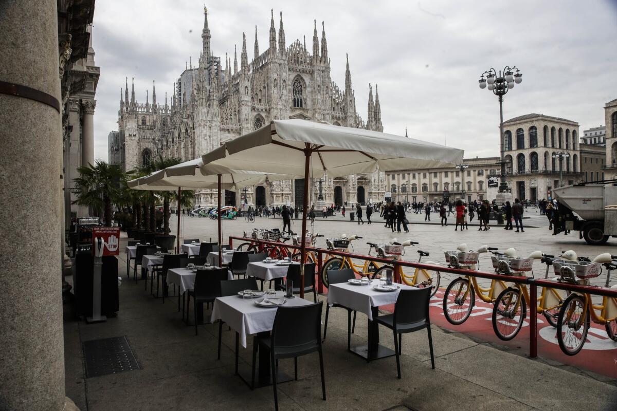 ARCHIVO -  mesas vacías en un restaurante en la Plaza del Duomo en Milán, Italia. 