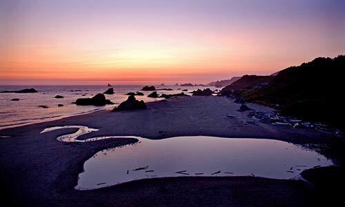 Sea stacks are silhouetted at sunset at Harris Beach State Park in southern Oregon.
