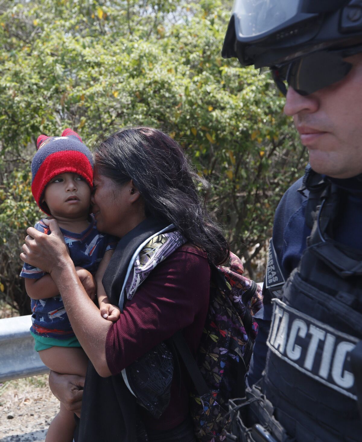 A Central American woman, with her son, is taken into custody April 22.