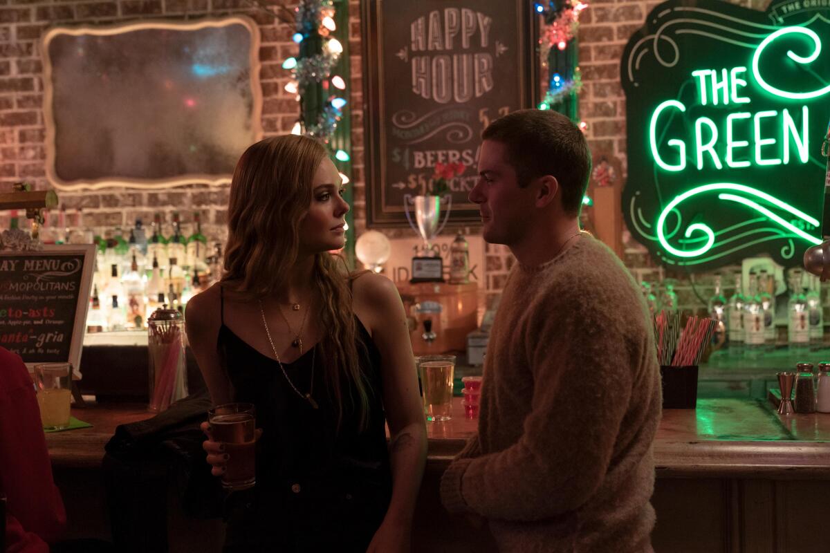 Elle Fanning and Colton Ryan stand at a bar in a scene from "The Girl from Plainville."